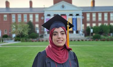 Hind Al Jurf in her cap and gown in front of Boyden Hall